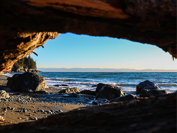 an ocean lookout captured through some rocks on the beach.