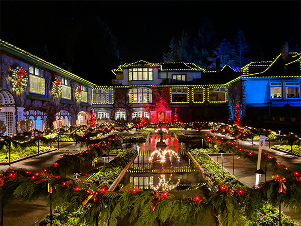 a large house covered in lights during the Butchart Gardens Christmas display.